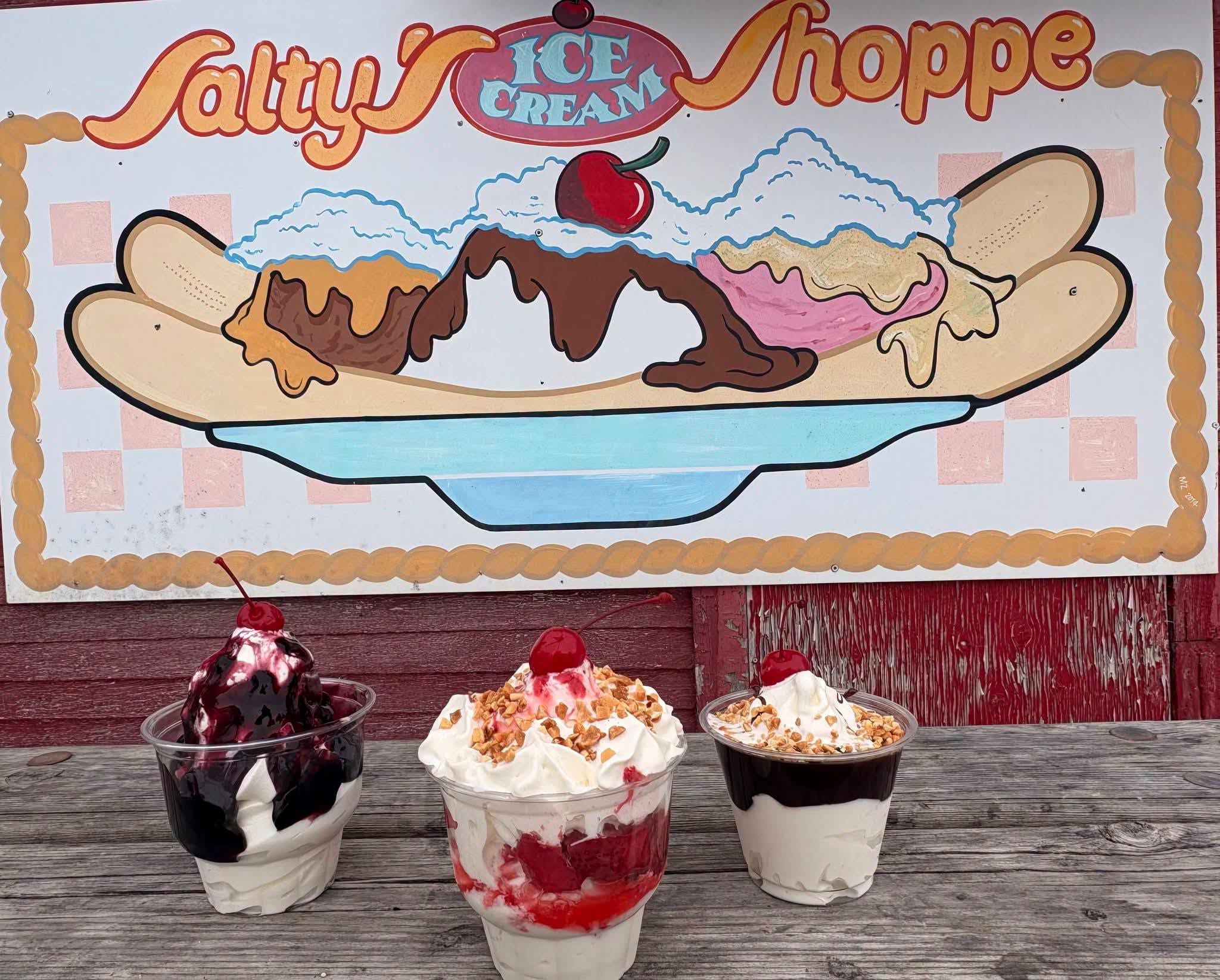 Three Salty’s ice-cream sundaes in front of the Ice Cream Shoppe sign