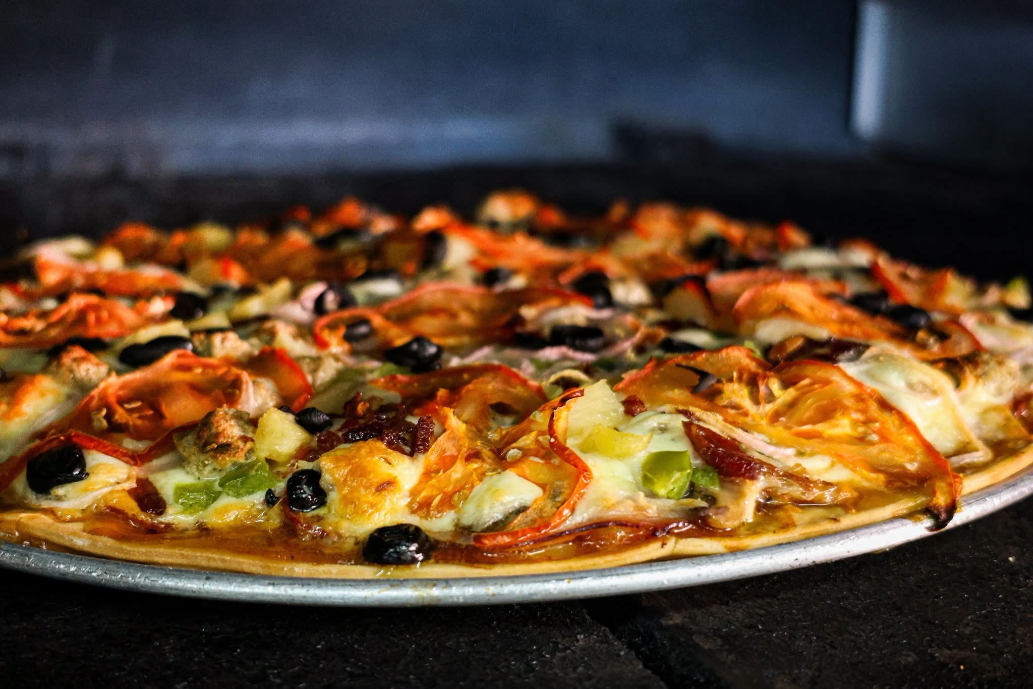 Close-up of a freshly baked loaded Salty’s pizza