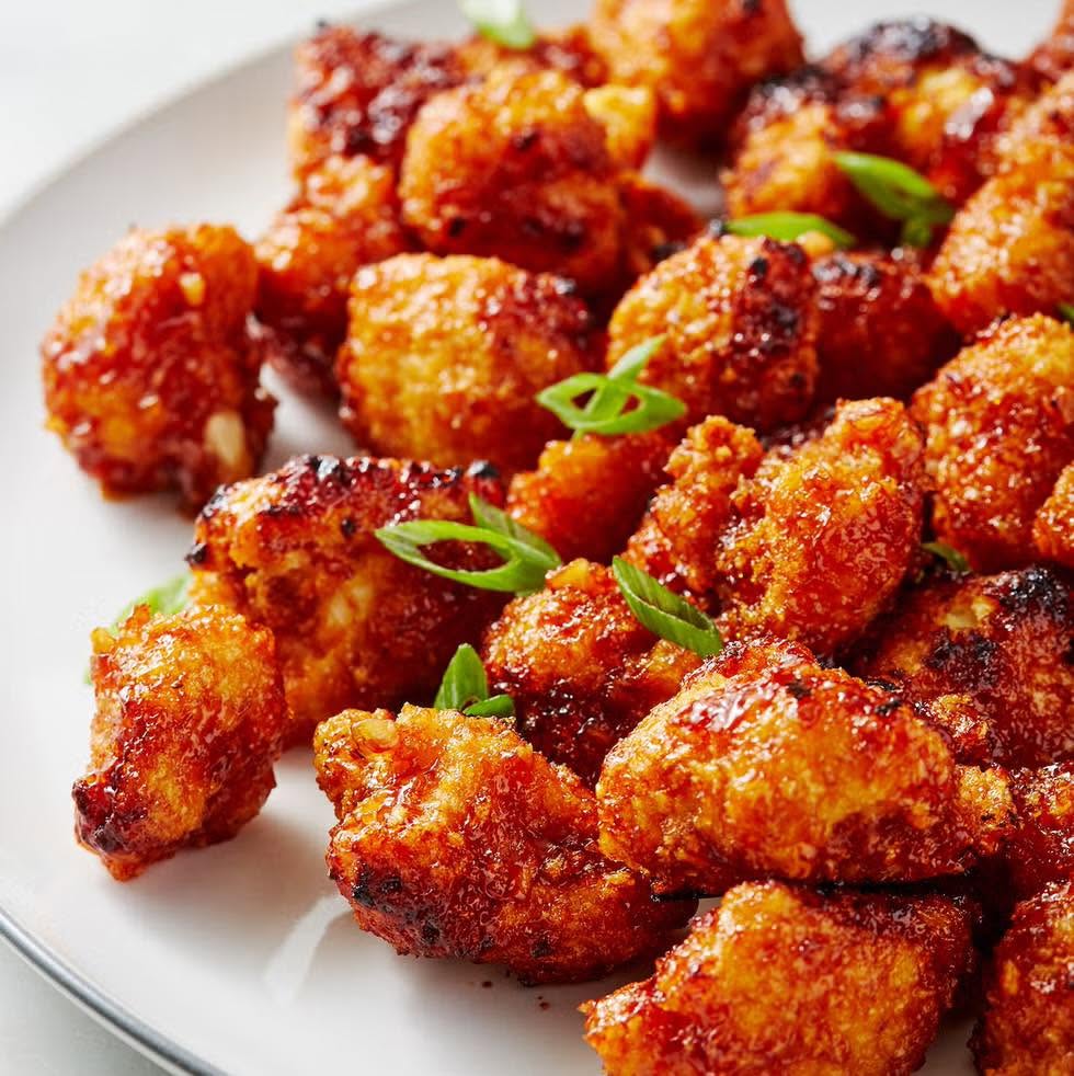 Golden crispy bites coated in a glossy sweet and spicy sauce